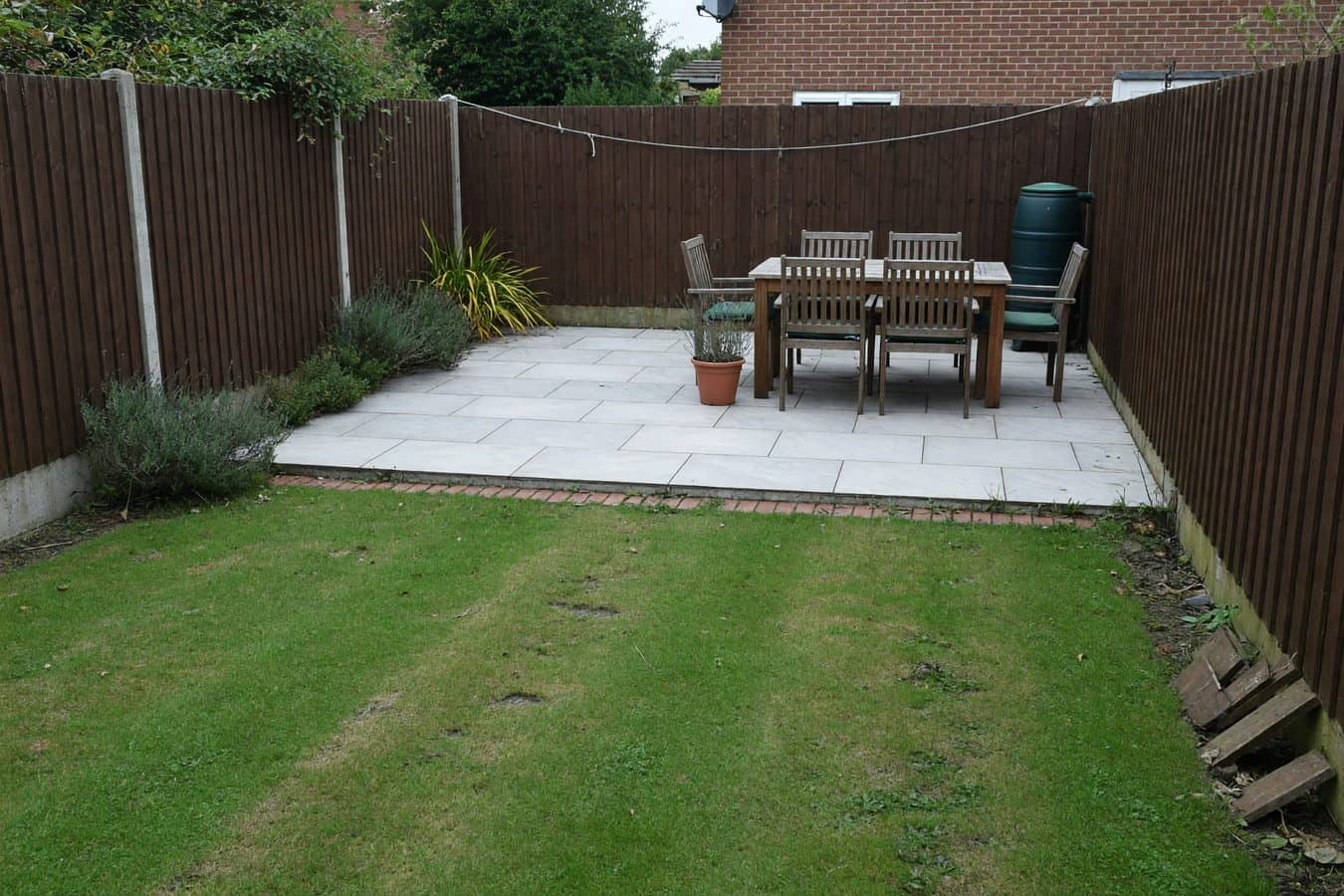 Pale porcelain dining patio at the far end of a Lancashire garden sitting in better light than the strip by the house