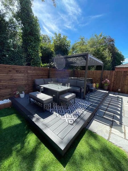 Composite decking patio with corner sofa, pergola, porcelain path and artificial grass