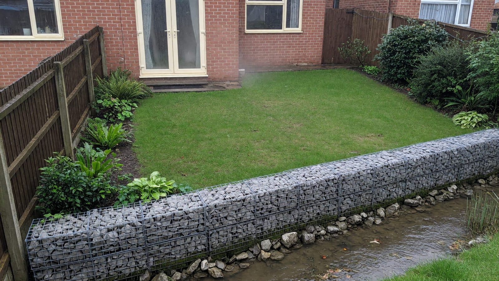 Gabion vs sleeper wall next to a stream