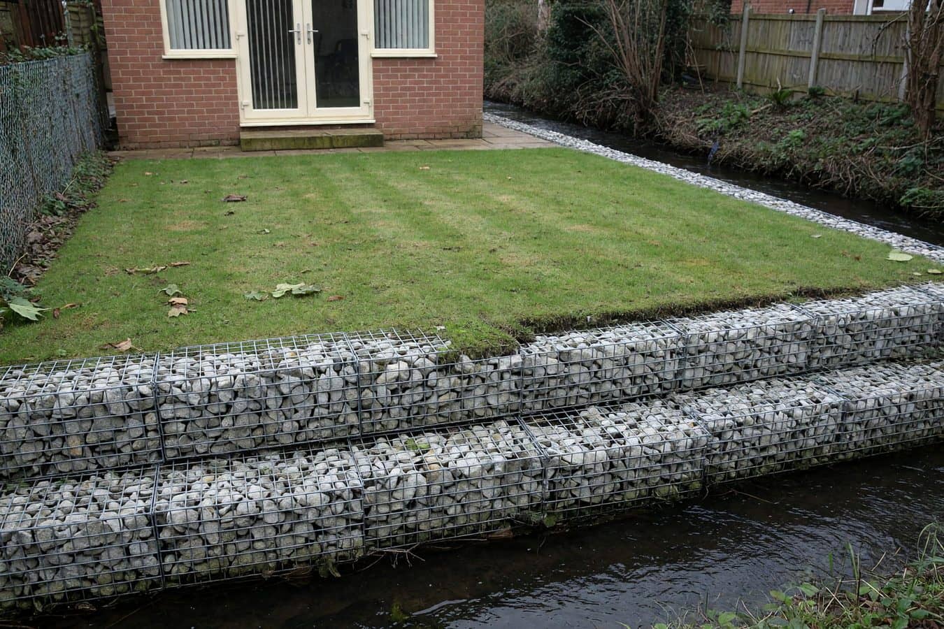 Gabion baskets forming the bank of a rear-garden boundary brook