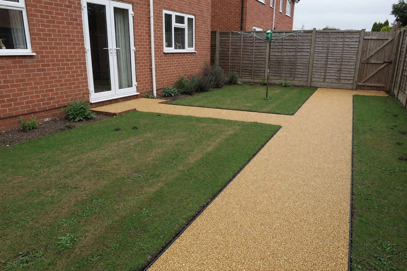 Finished buff resin bound garden path beside a lawn in a modest Lancashire rear garden