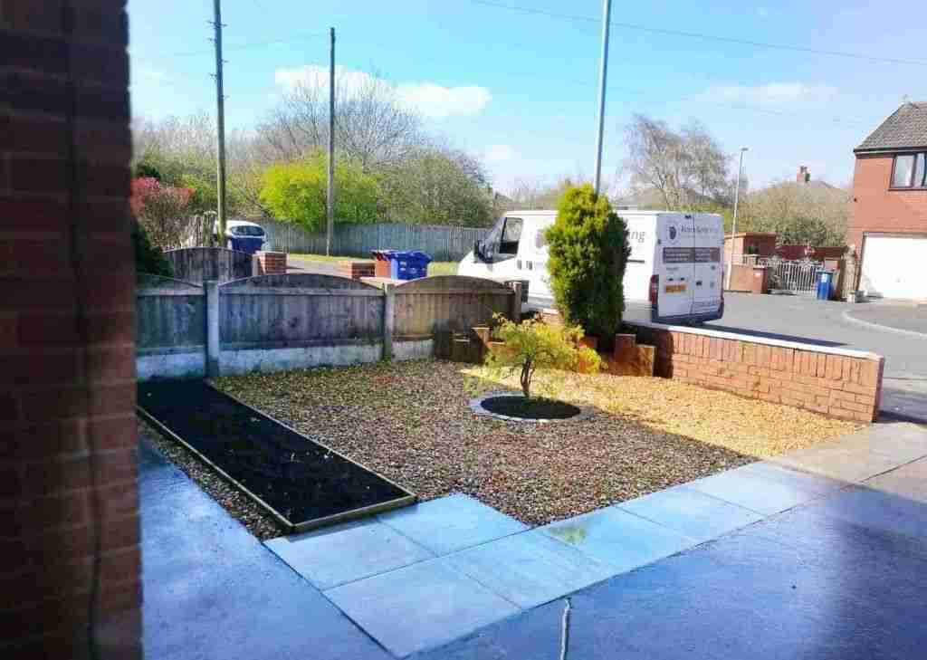 A small garden with a new flower bed, flint gravel, new drainage and a custom built raised bed at the back