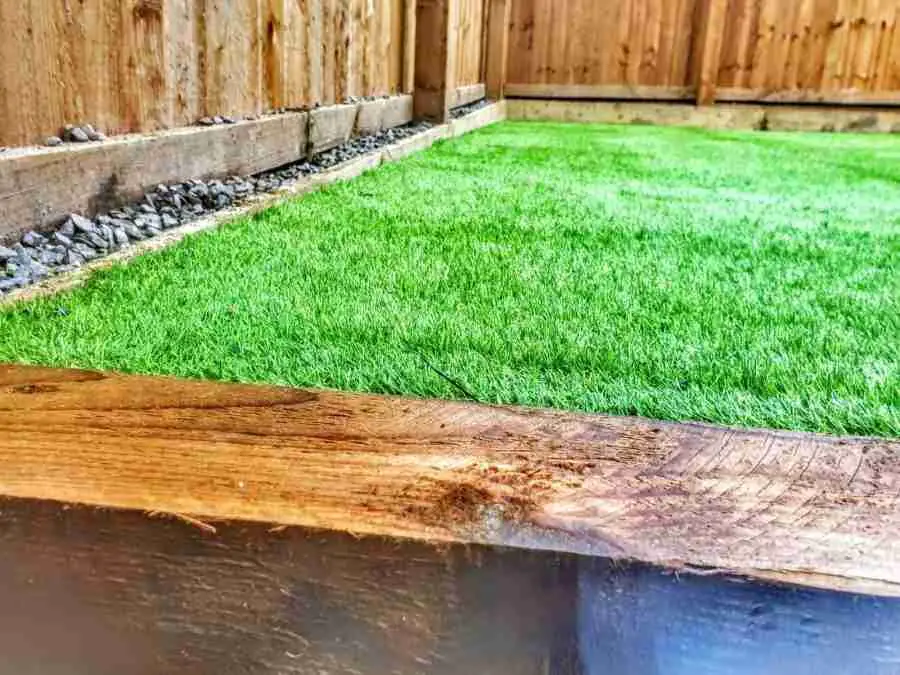 Close up shot of some landscaping work in Buckshaw village. The photo includes artificial grass, wooden sleepers, gravel and fencing