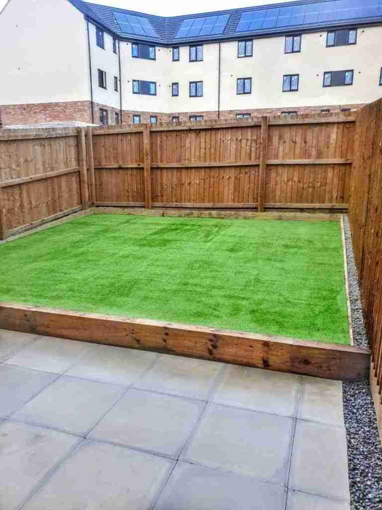Raised artificial grass area to help with drainage. The edge is made from treated timber sleepers.