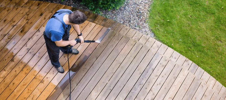 Man cleaning decking with a power washer