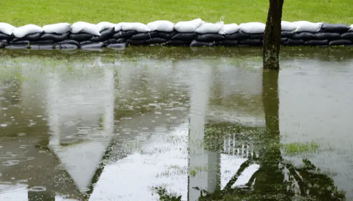 Flooded garden with sandbags keeping in large pool of water