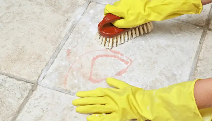 Scrubbing stone paving with a brush by hand
