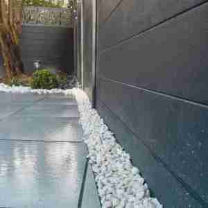 Composite fencing with white paving and green turf