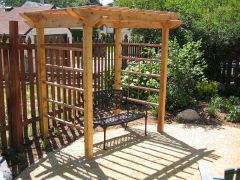 wooden pergola 2 Wooden pergola with black metal bench underneath it